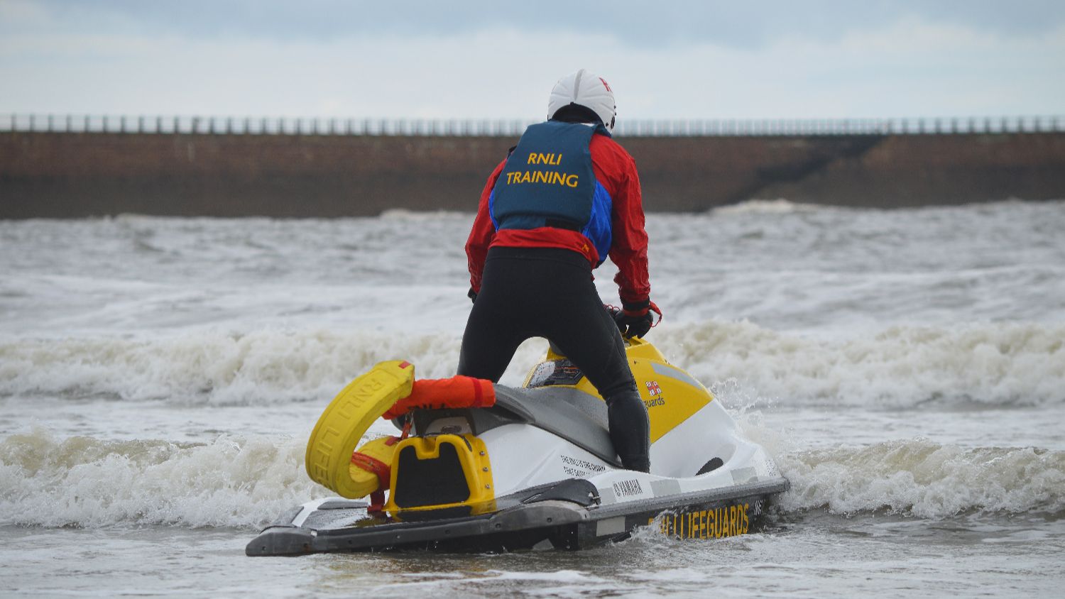 An RNLI lifeguard onboard a rescue watercraft (RWC) taking part in lifeguard supervisor training at Roker in Sunderland.