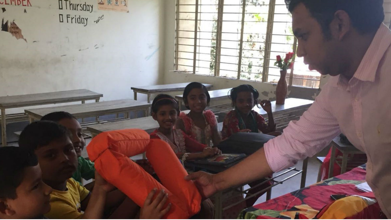 Bangladesh class room and students, teacher showing low cost equipment Bottle Ring
