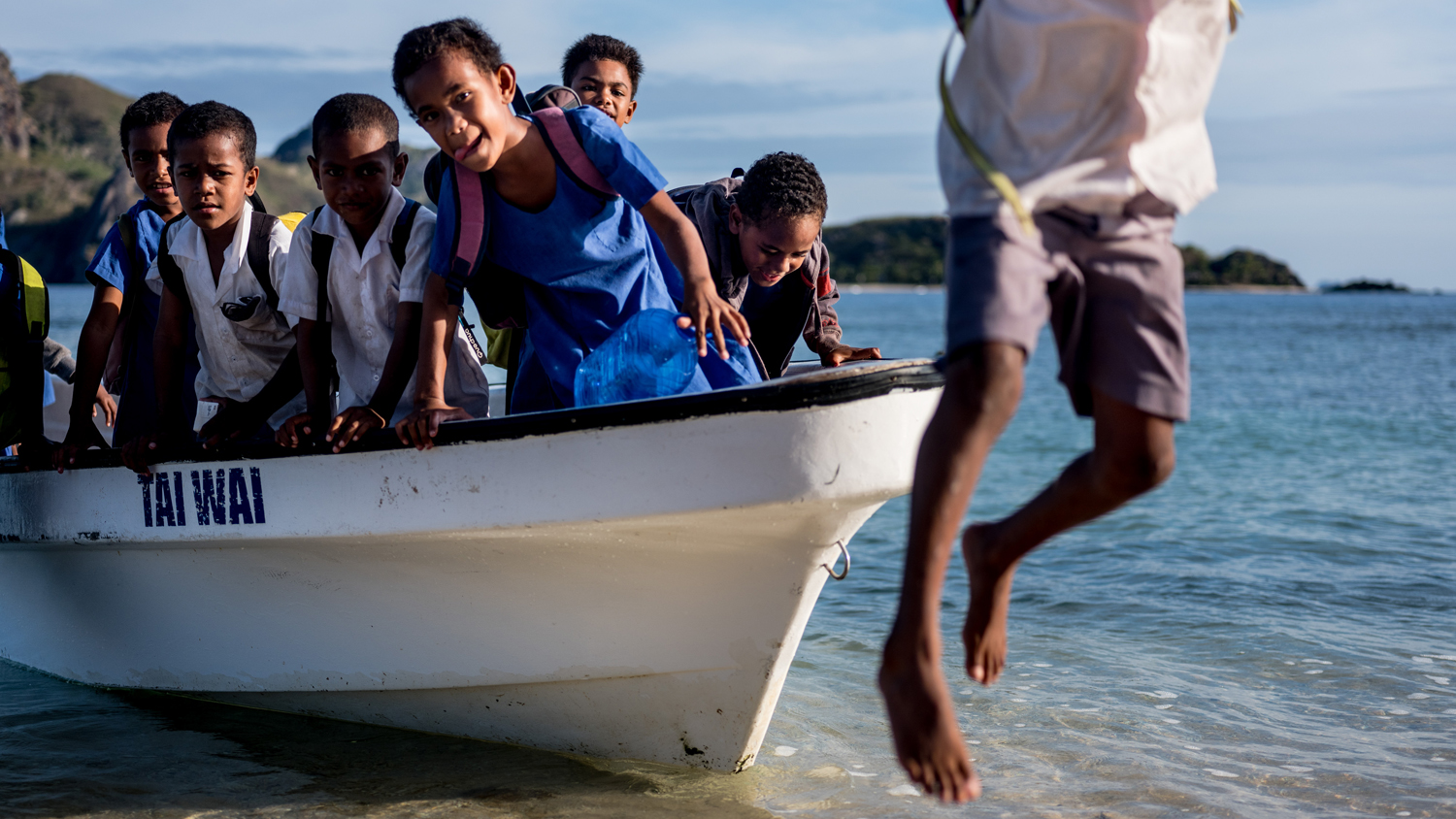 Children in Fiji return from school by boat