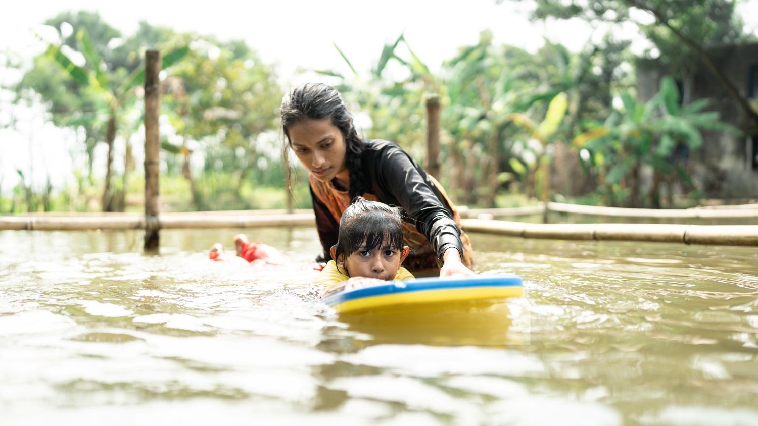 Child having a swimming lesson in Bangladesh