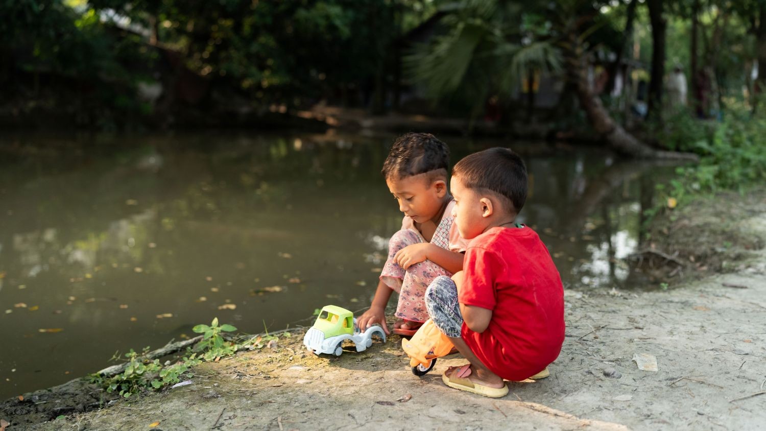 Children in Bangladesh playing by pond without adult supervision