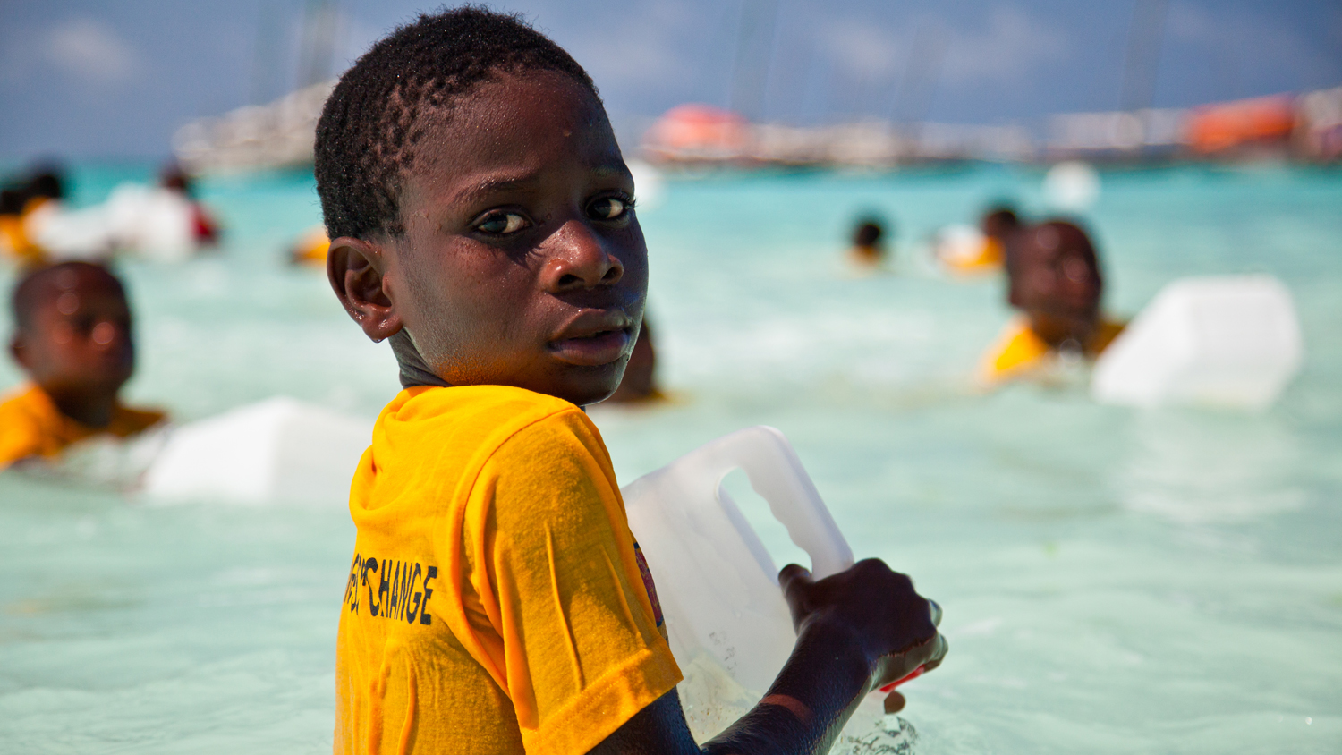 A boy holding a plastic container float during an Aquatic Survival lesson in Nungwi, Zanzibar