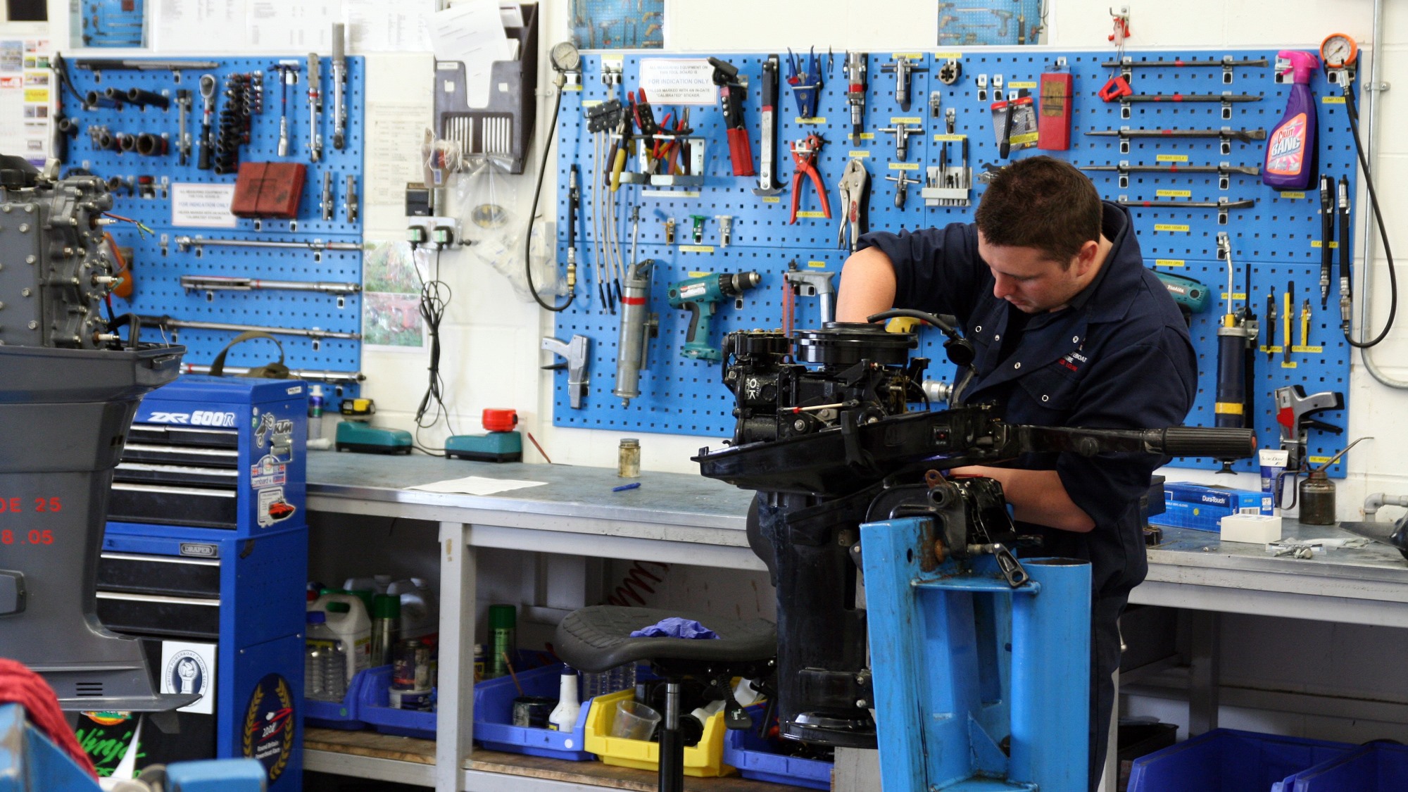 Mechanic working on an outboard engine at the Inshore Lifeboat Centre