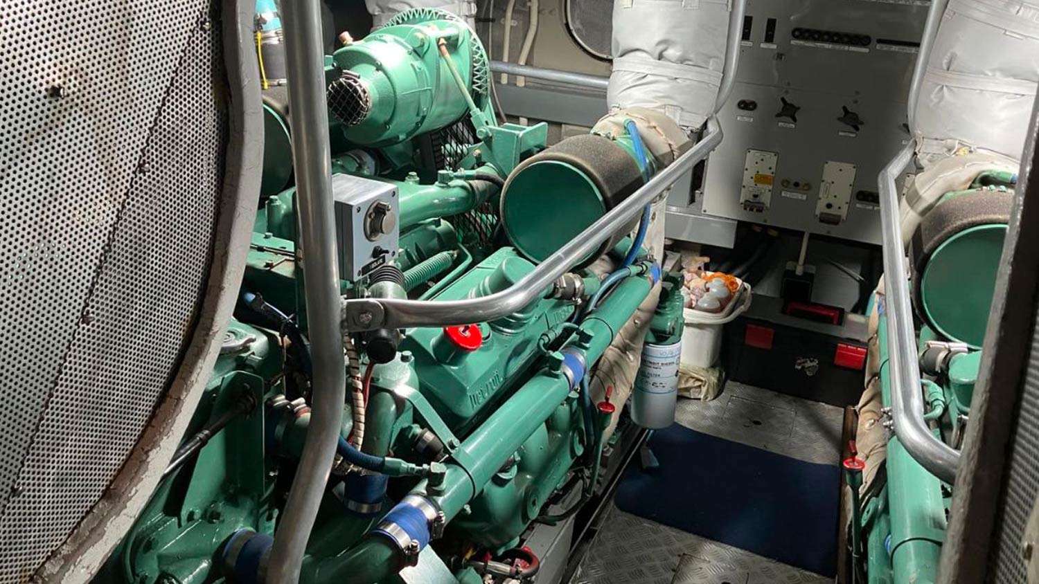 A look at the Detroit diesel engines inside the engine room onboard a Tyne class lifeboat. The engines are painted light navy green. 