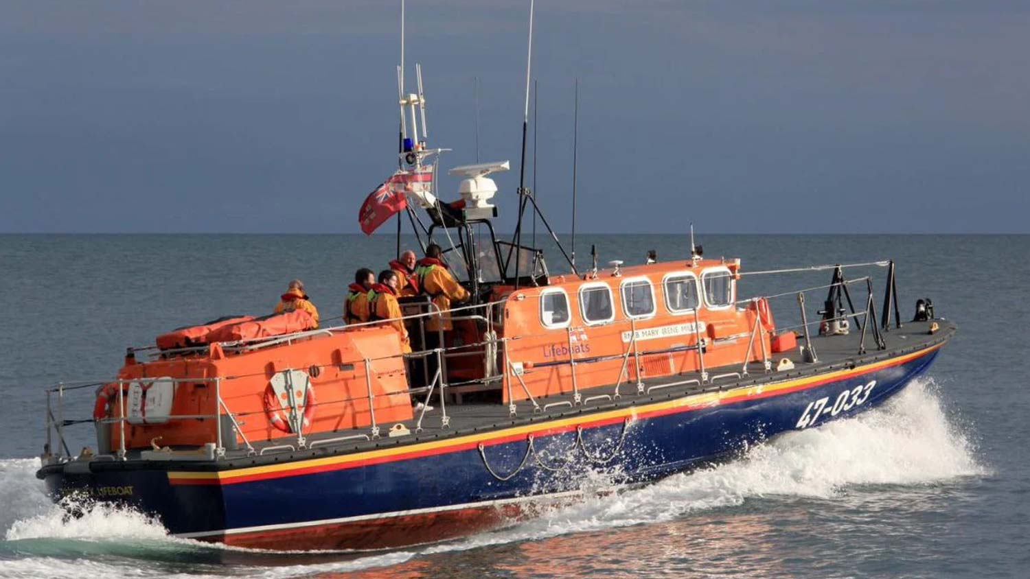 Tyne class all-weather lifeboat cruises along calm seas under grey skies
