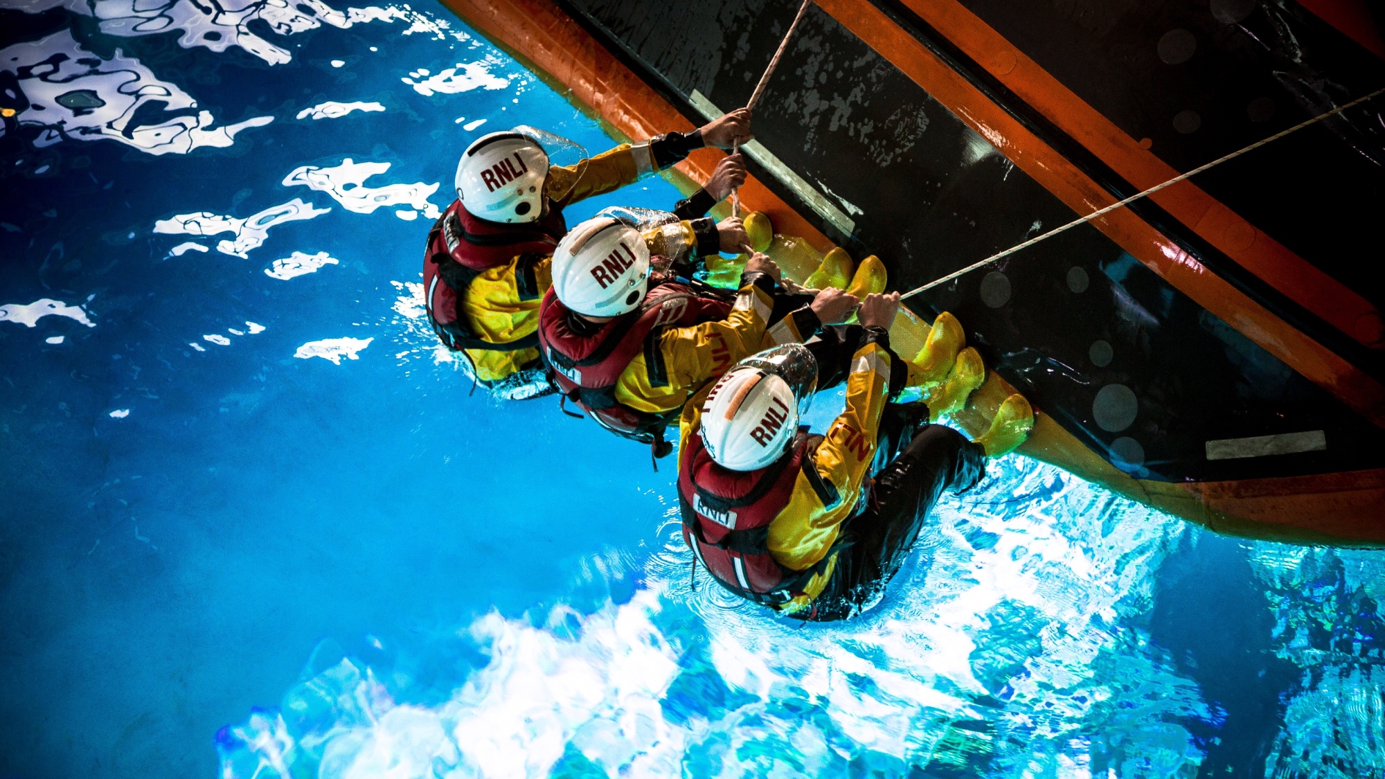 Lifeboat crew self-righting a D class lifeboat in RNLI College’s wave tank