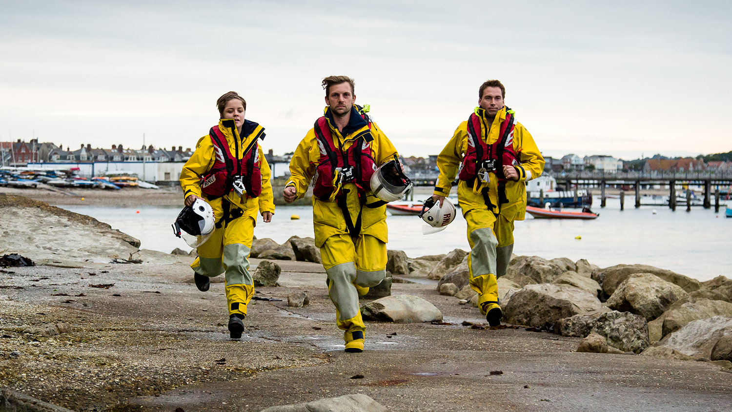 Swanage RNLI crew members running along the harbour